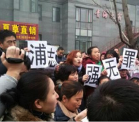 Supporters of convicted human rights lawyer Pu Zhiqiang (浦志强) chant and hold up “Pu Zhiqiang is Innocent” outside the court during his trial.